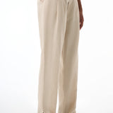 Beige pleated pants worn by a woman on a white background