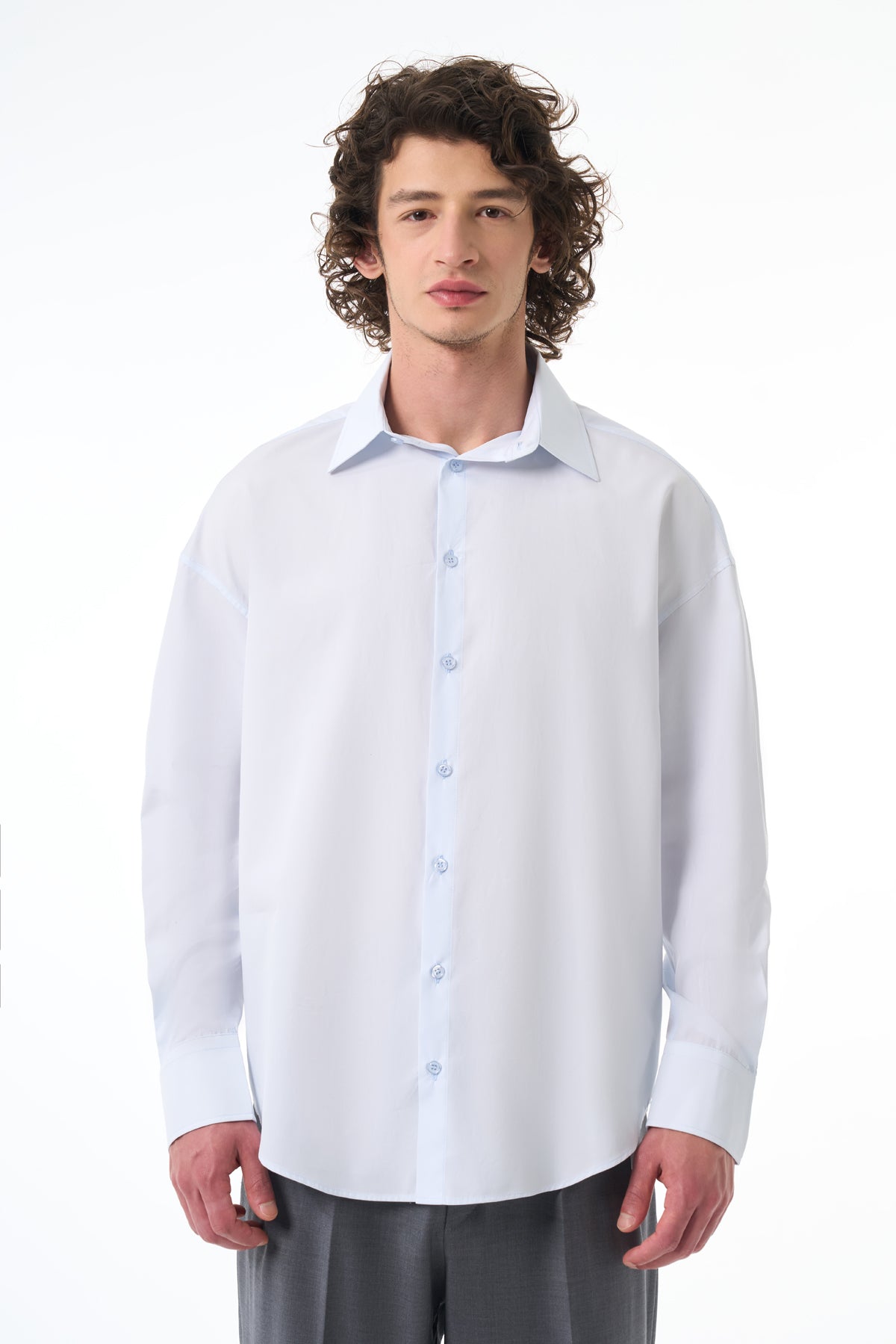 Man wearing a light blue dress shirt with a white background