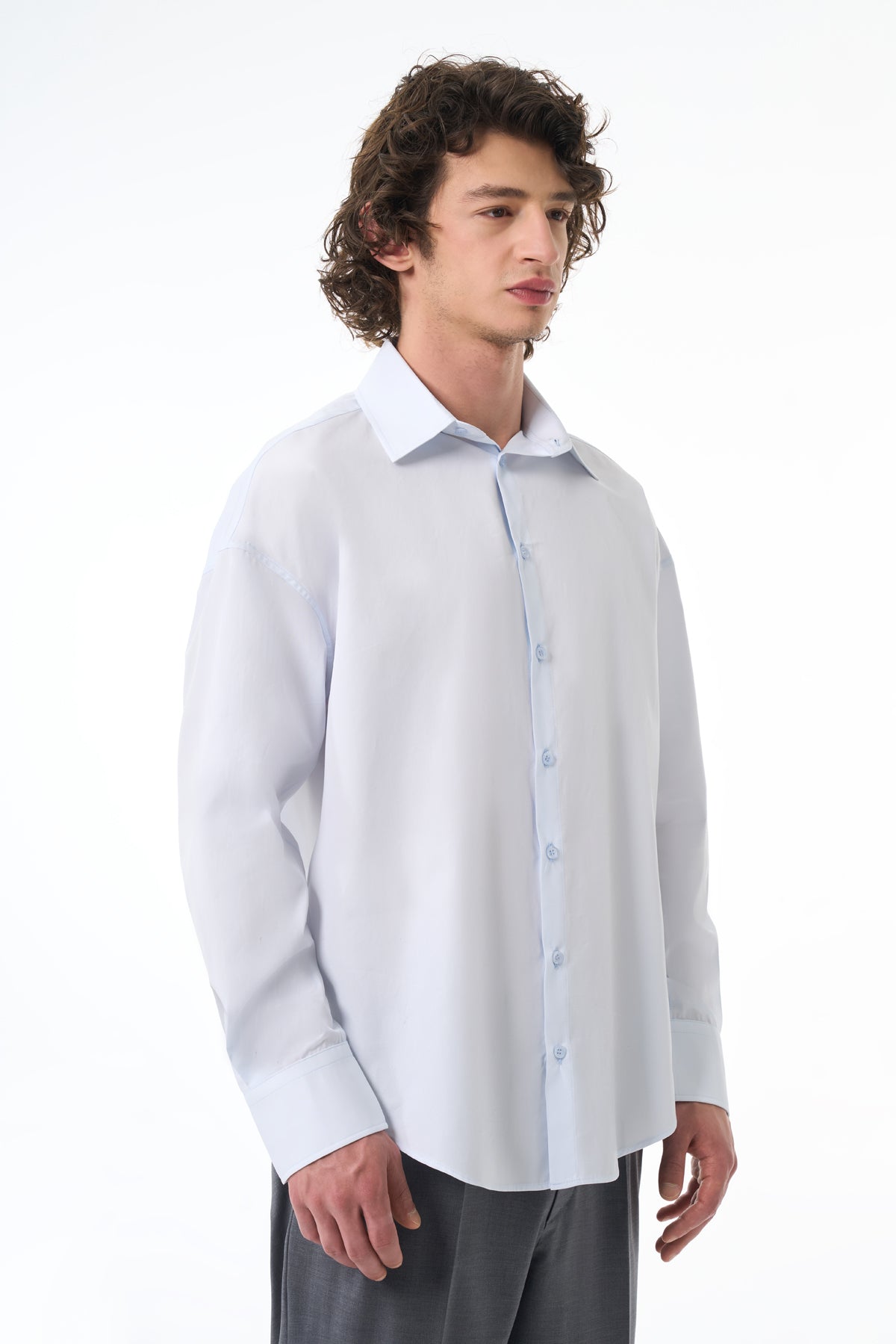Man wearing a light gray dress shirt with a white collar on a white background
