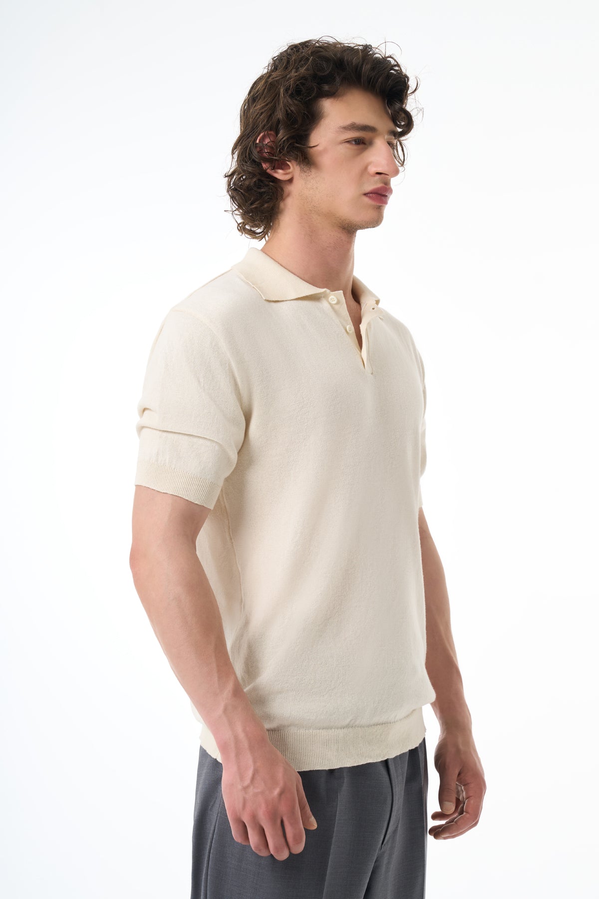 Man wearing a beige short-sleeve polo shirt on a white background