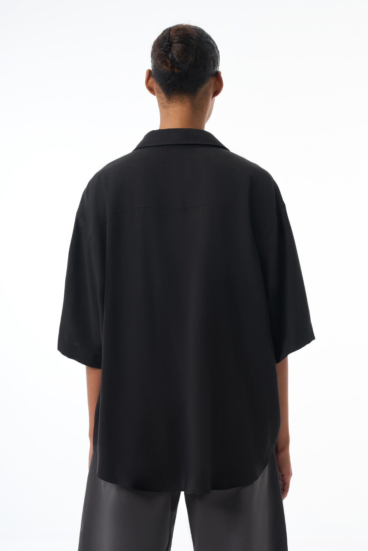 Woman wearing a black oversized shirt on a white background