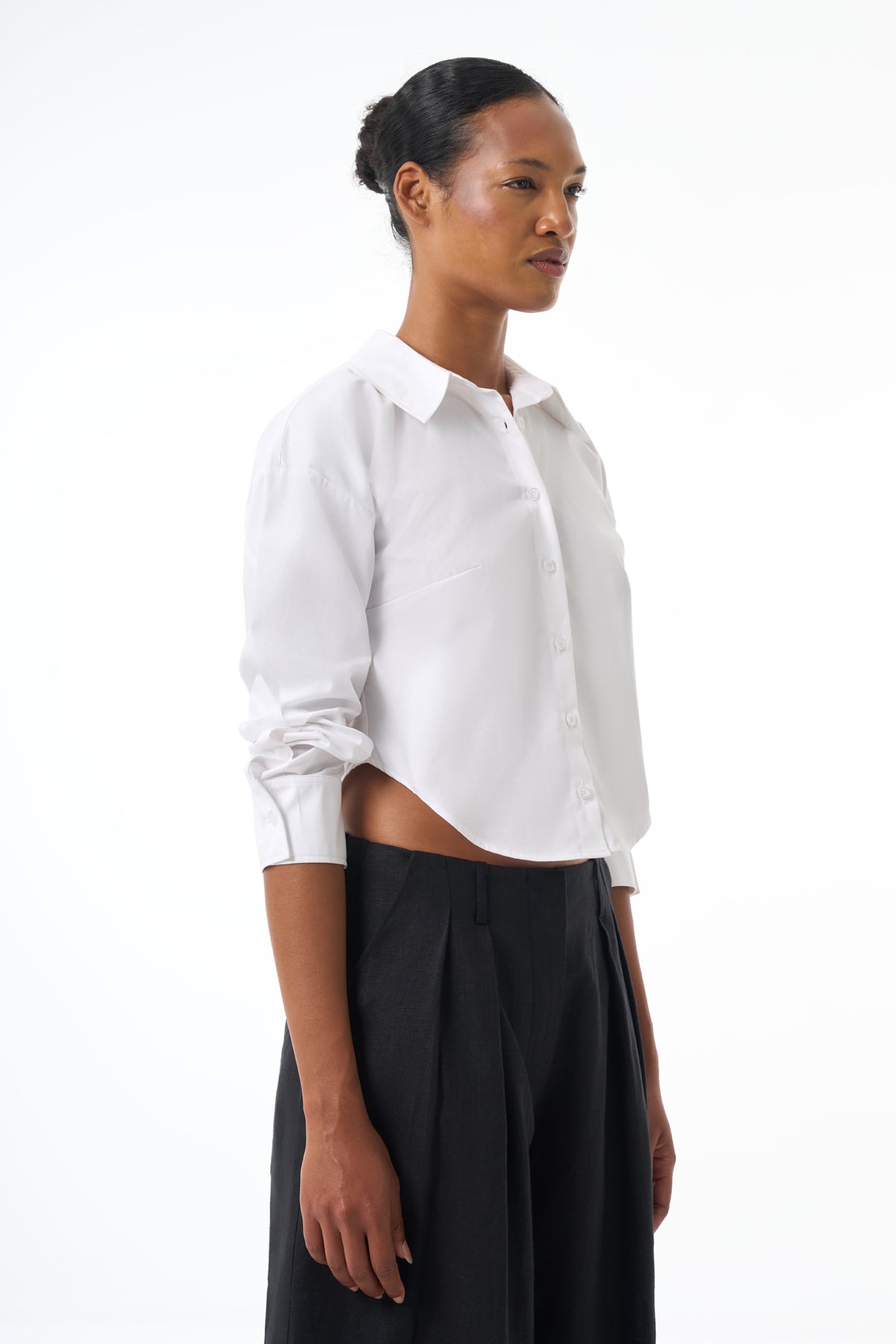 Woman wearing a white shirt and black pants on a white background