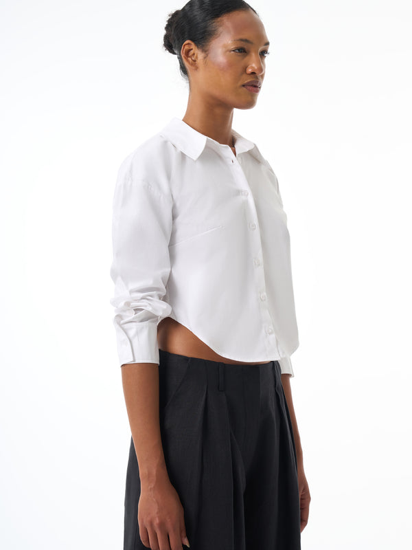 Woman wearing a white shirt and black pants on a white background