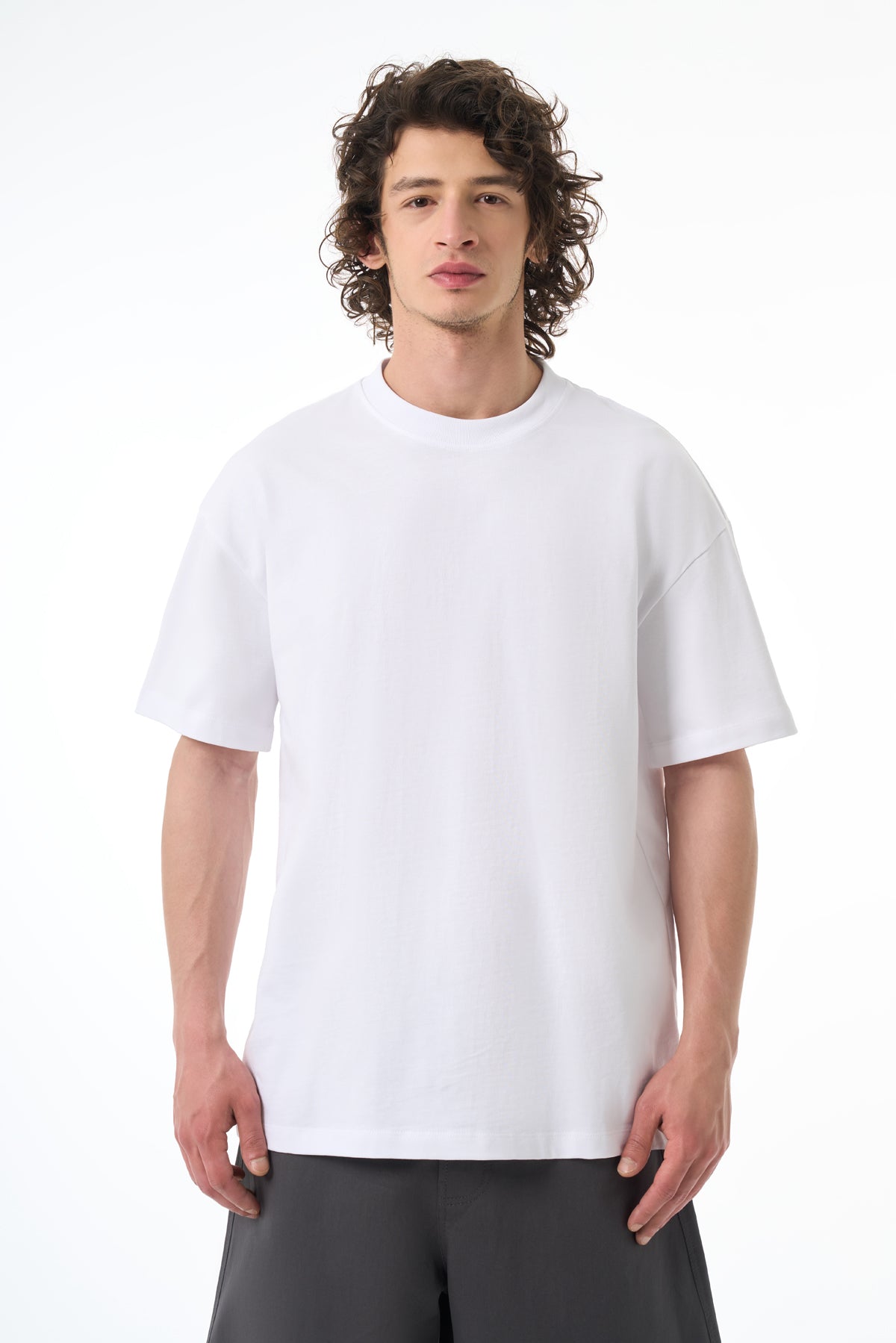 Man wearing a plain white t-shirt on a white background