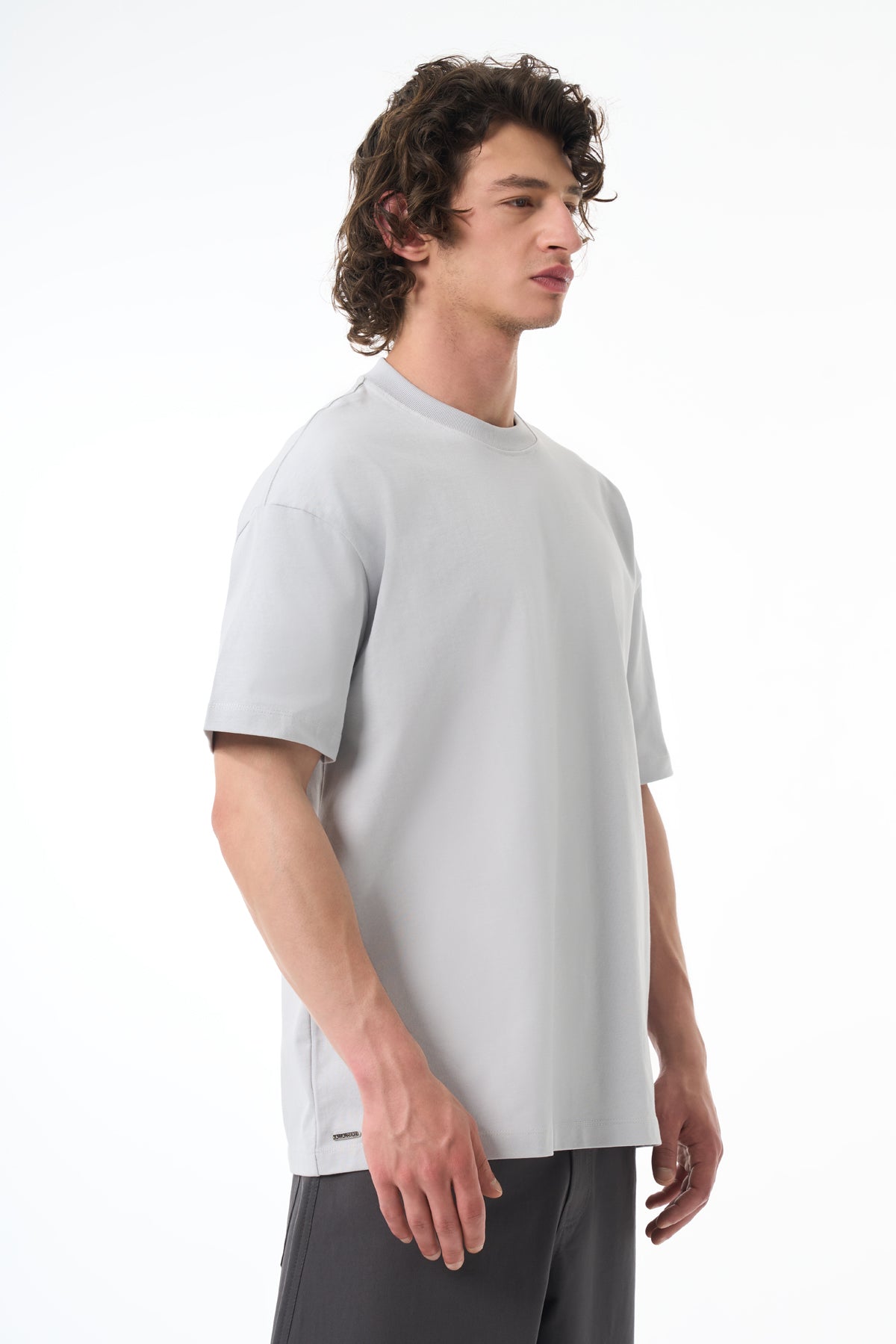 Man wearing a light gray t-shirt on a white background