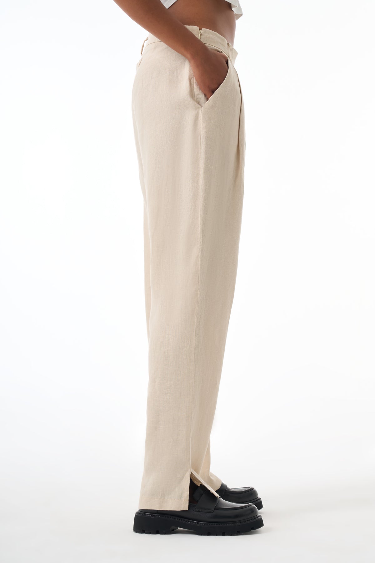 Beige pants worn by a woman on a white background