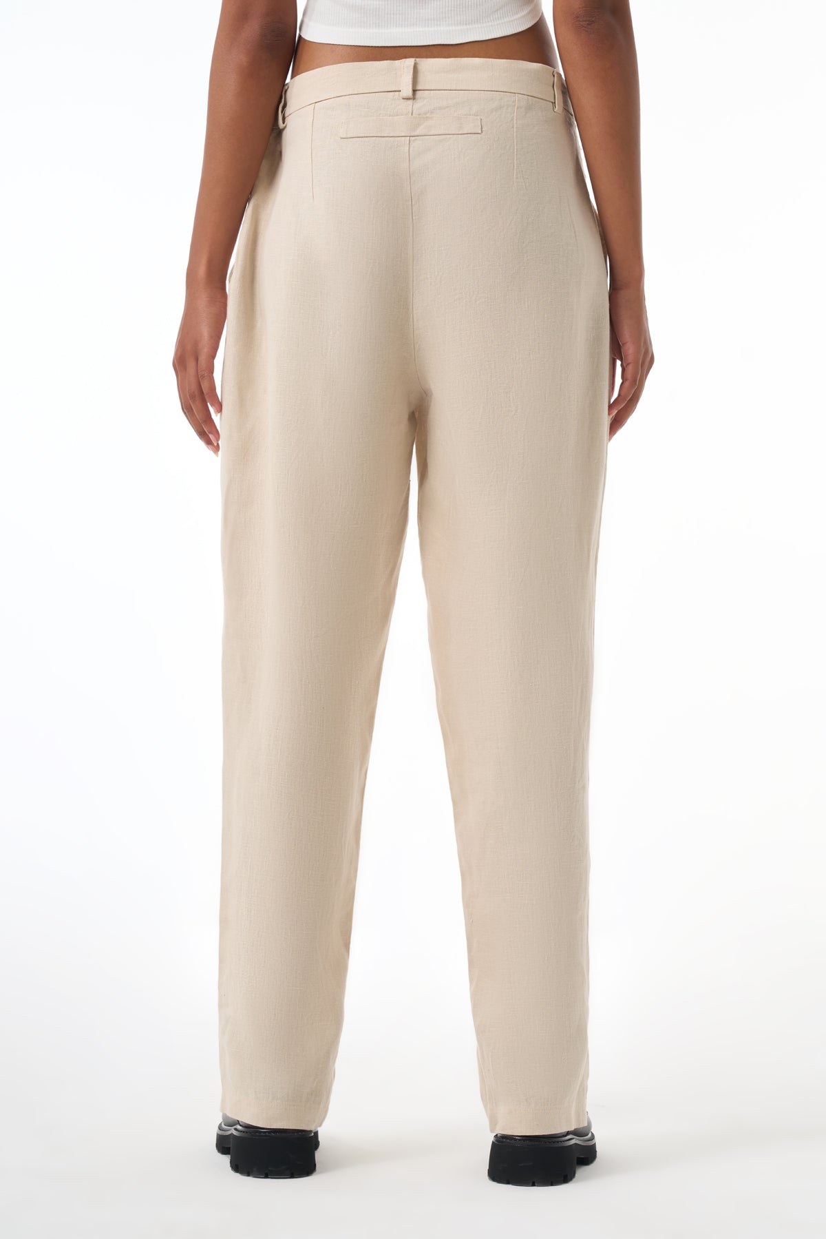 Beige pants worn by a woman on a white background