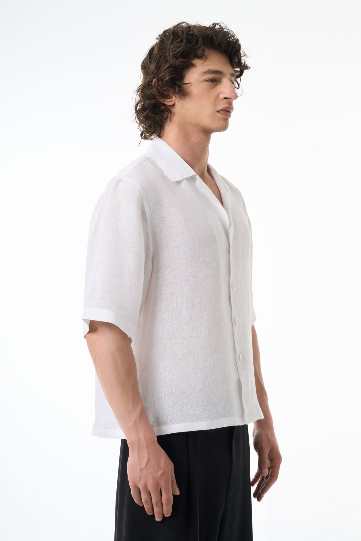 Man wearing a white shirt and black pants on a white background