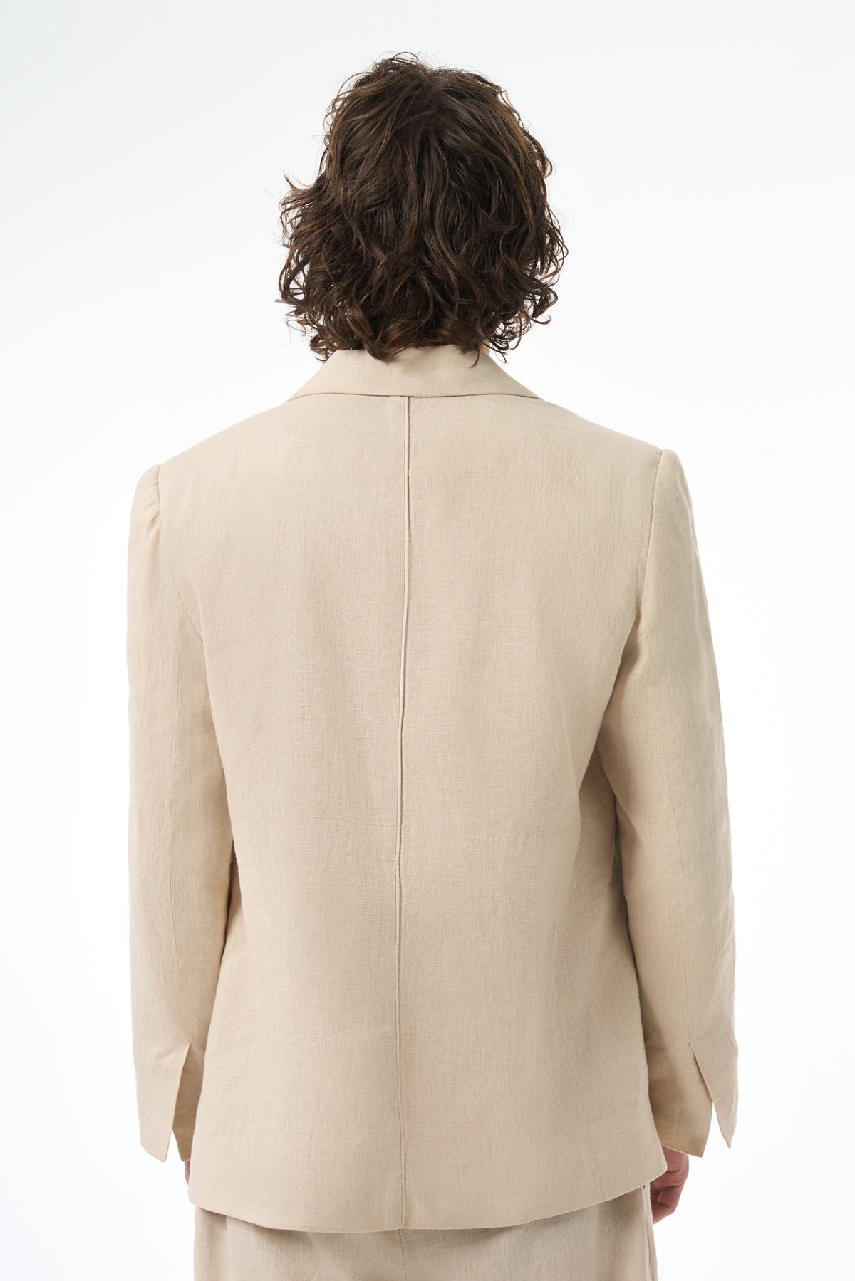 Beige suit jacket worn by a man on a white background