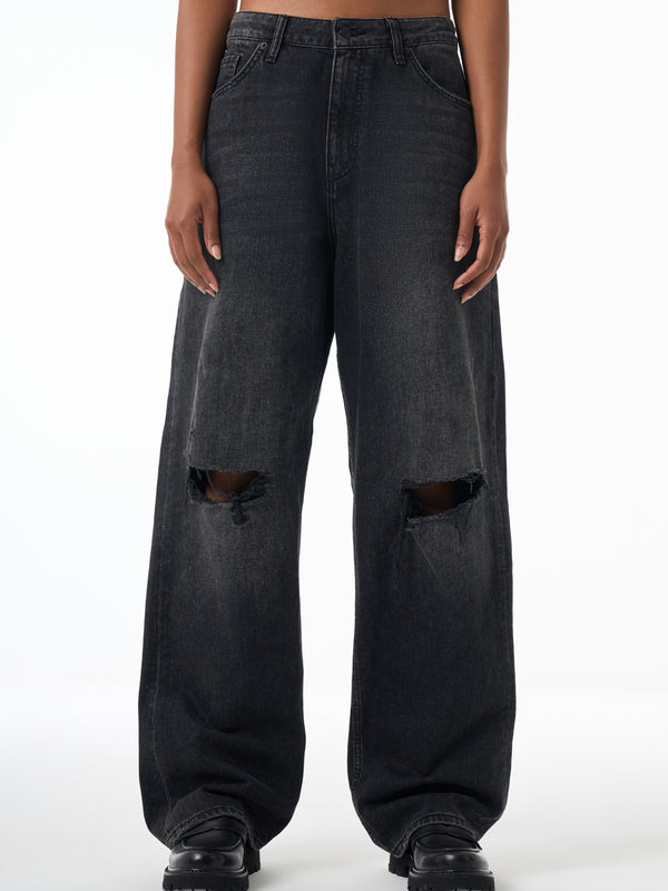Woman wearing black distressed jeans on a white background