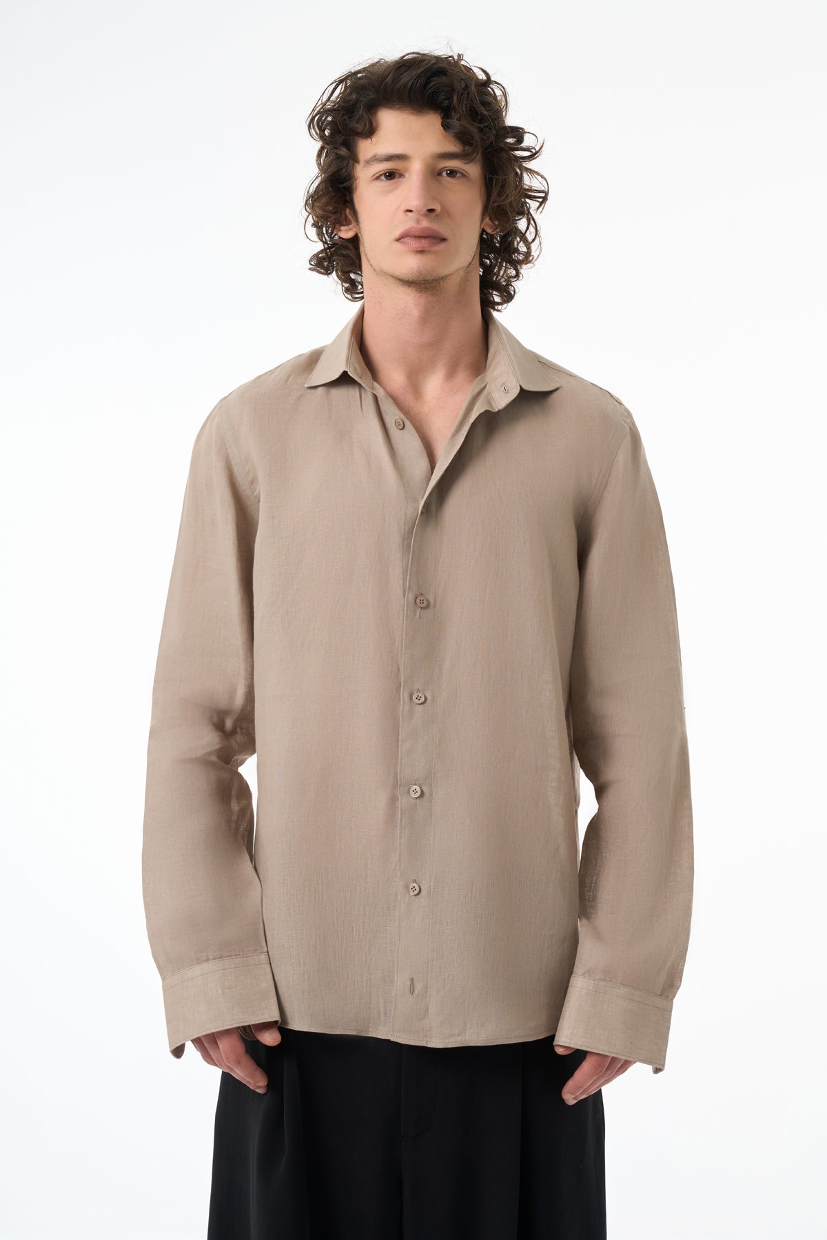 Man wearing a beige button-up shirt on a white background